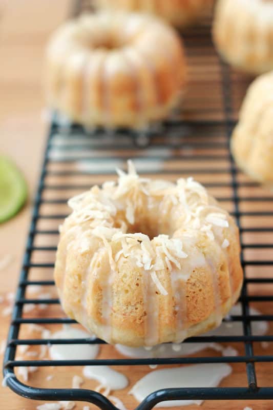 mini banana loaf on a cooling rack drizzled with glaze and sprinkled with toasted coconut