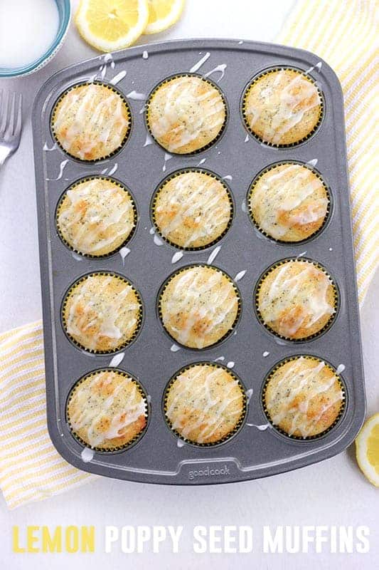 12 cup muffin tin filled with baked lemon muffins that are drizzled with icing. 