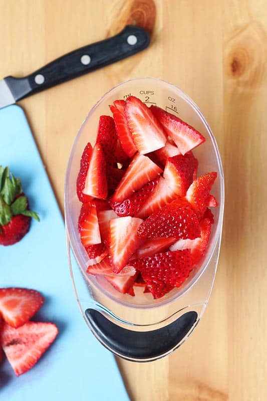 measuring cup filled with sliced strawberries