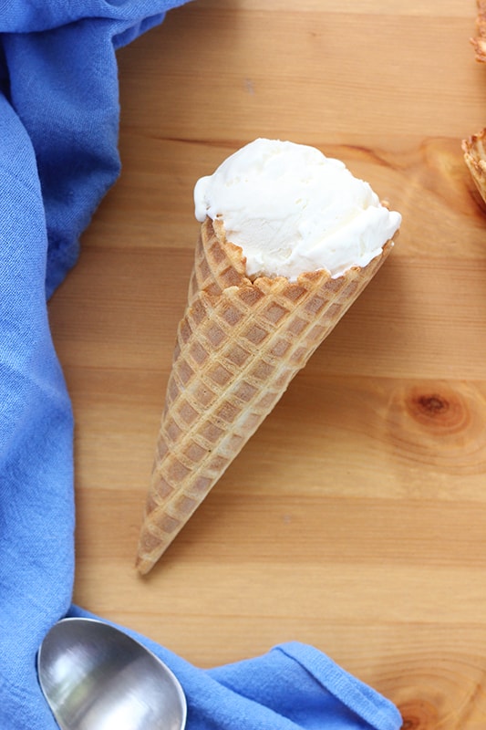 Vanilla ice cream in waffle cone on table