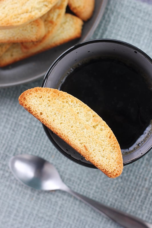 one piece of biscotti balancing on the side of a coffee cup