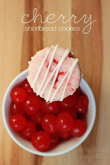 Cherry shortbread cookie balanced on top of bowl of cherries