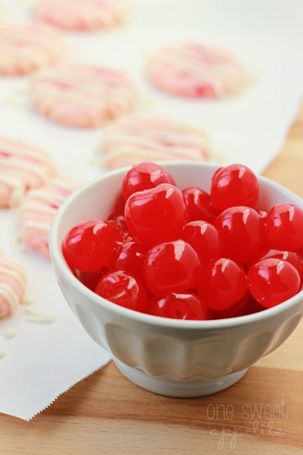 bowl of cherries with shortbread cookies behind on a piece of parchment