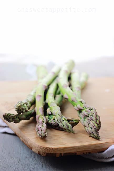 fresh asparagus on a wooden cutting board