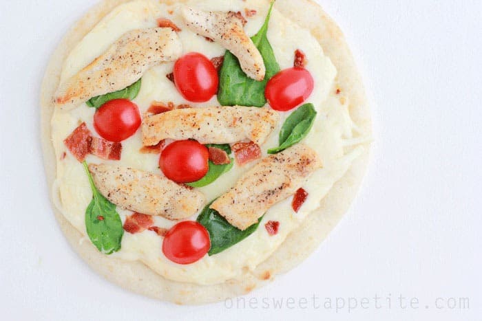 mini chicken pizza sitting on a white table