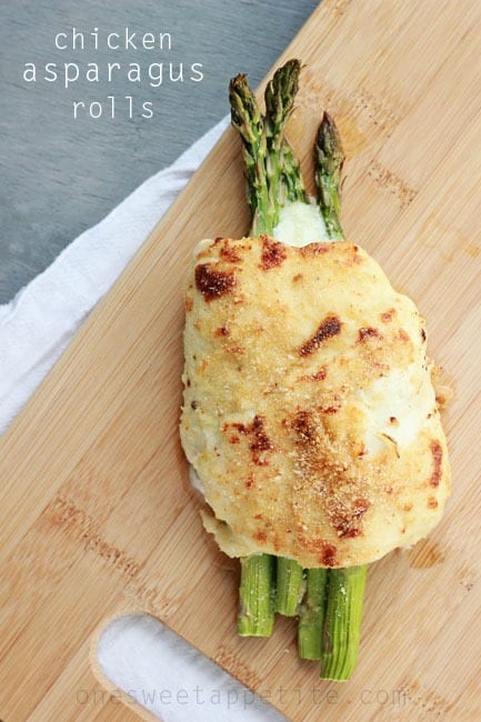 asparagus wrapped in chicken and cheese on a wooden cutting board