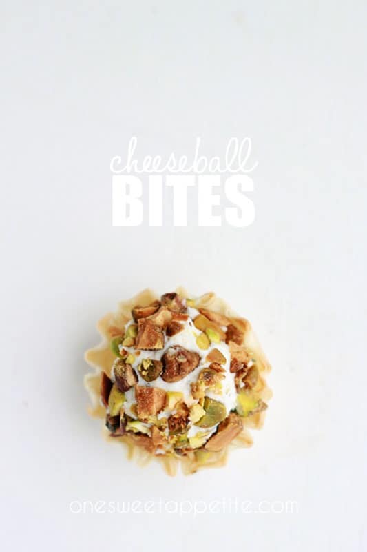 one cheese ball bite covered in pistachios on a white surface