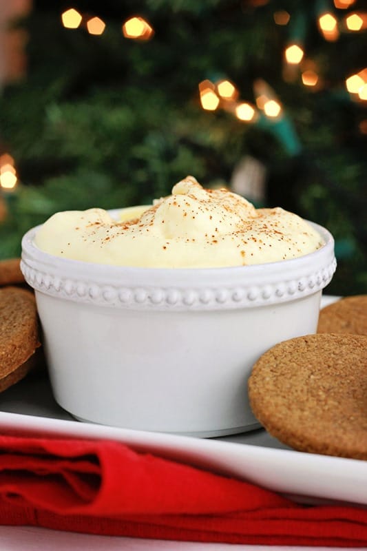 white dish filled with eggnog dip surrounded by ginger cookies