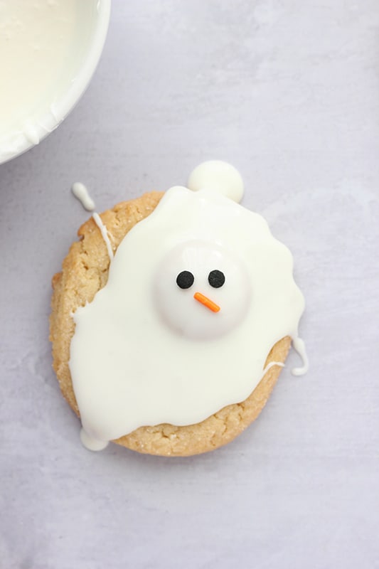 Sugar cookie with melted chocolate drizzled on top to resemble snowman