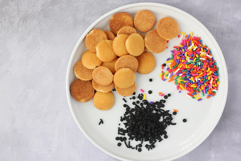 Mini vanilla wafers, rainbow and place sprinkles on white plate