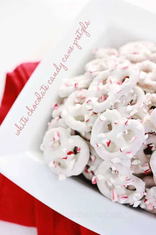 white serving bowl filled with pretzels coated with chocolate and crushed cnadies