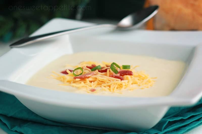 Wisconsin cauliflower soup in white bowl topped with cheese and bacon