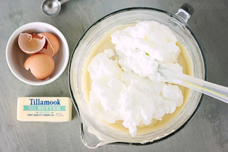 whipped egg whites on top of waffle batter in a glass bowl