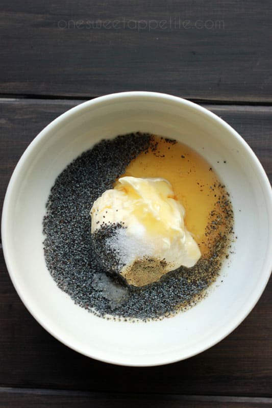 top down image showing g a white bowl filled with vinegar, mayonnaise, and poppy seeds 