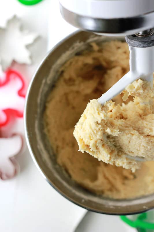 cookie dough inside of a stand mixer fitted with the paddle attachment