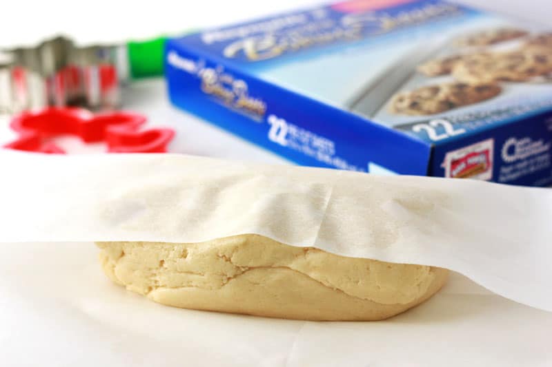 dough being rolled into parchment paper