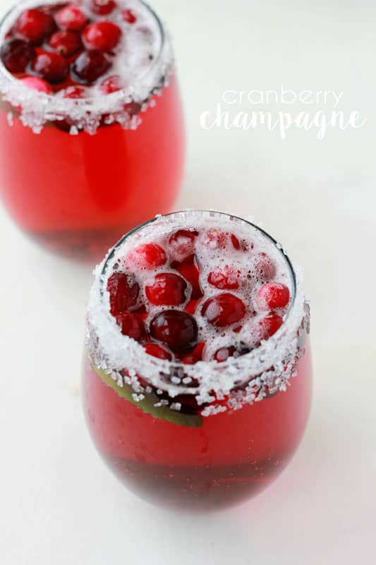 two sugar rimmed glasses filled with cranberry juice and champagne