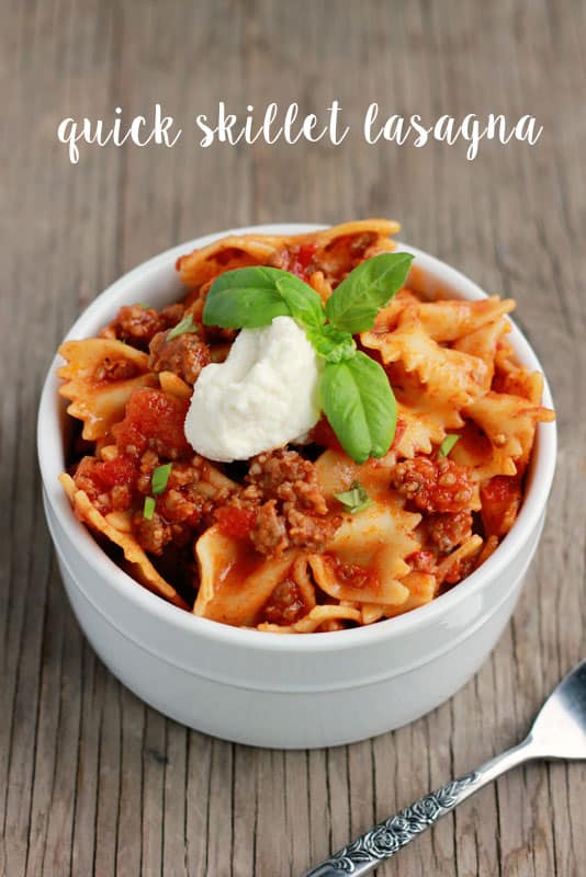 lasagna pasta in a white dish topped with ricotta and basil