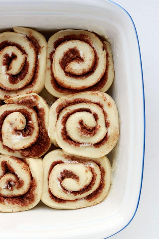 unbaked sweet rolls in a white pan