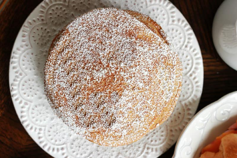 gingerbread pancakes stacked on white plate and dusted with powdered sugar