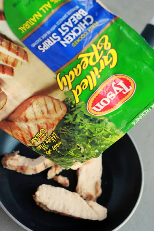 bag of frozen grilled chicken being poured out onto a pan