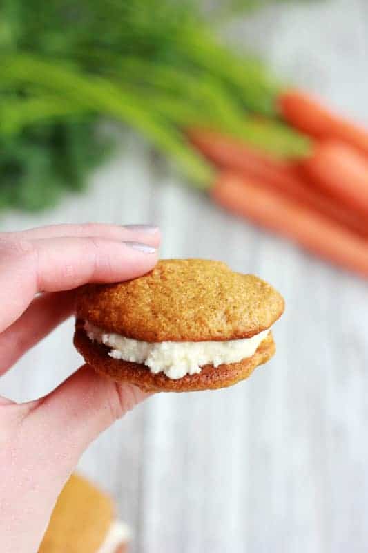 hand holding a whoopie pie filled with frosting