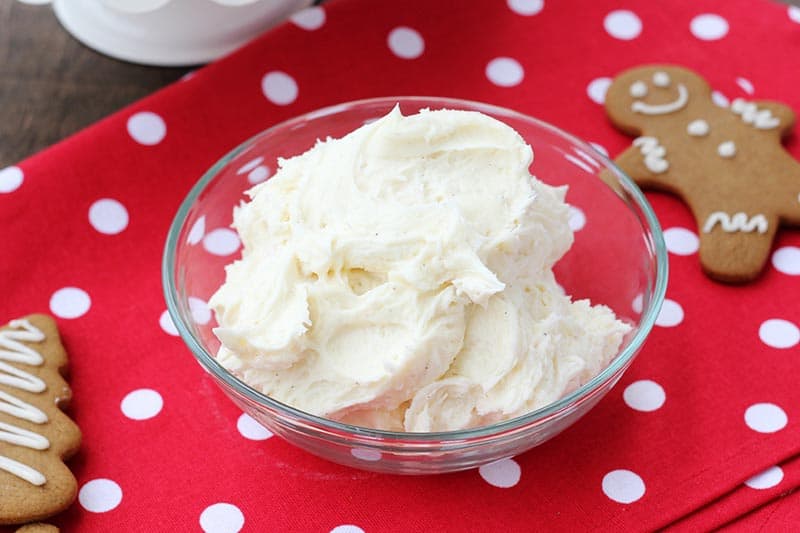 Eggnog Frosting in a bowl with gingerbread cookies around