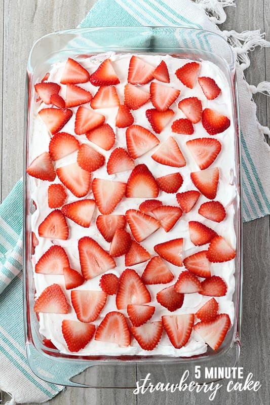 strawberries layered on top of whipped topping inside of a 9x13 dish