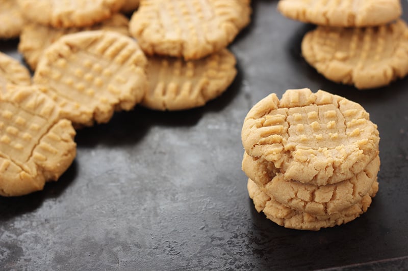 peanut butter cookies laid across black cookie tray