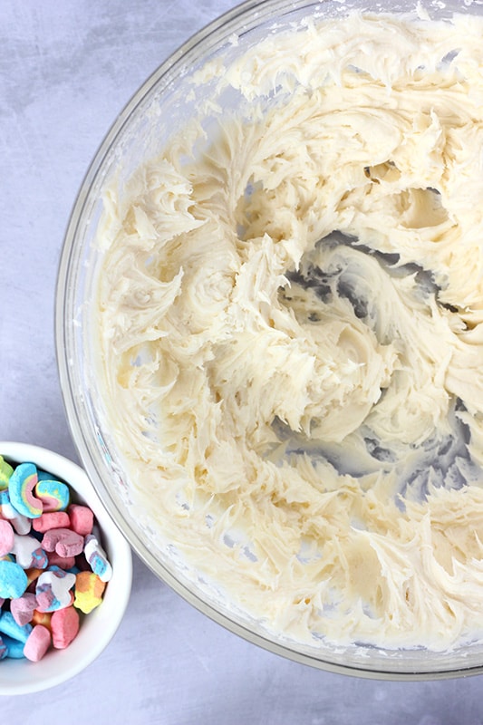 Cereal Milk Frosting in a glass bowl with a small bowl of marshmallows next to it