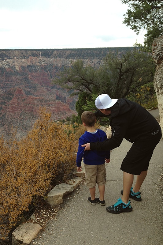 dad and son looking over the edge of the grand canyon