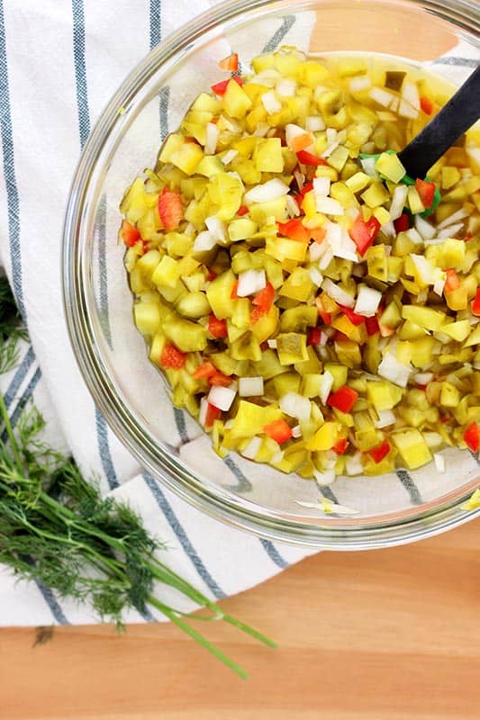 glass bowl filled with quick pickle relish with fresh dill on the side