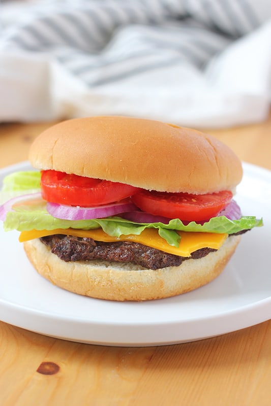 air fry cheeseburger on a white plate with toppings