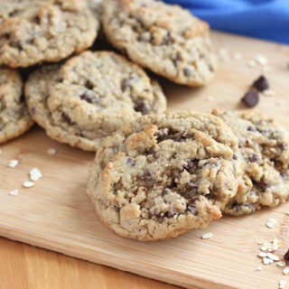 oatmeal chocolate chip cookies stacked on cutting board with blue napkin