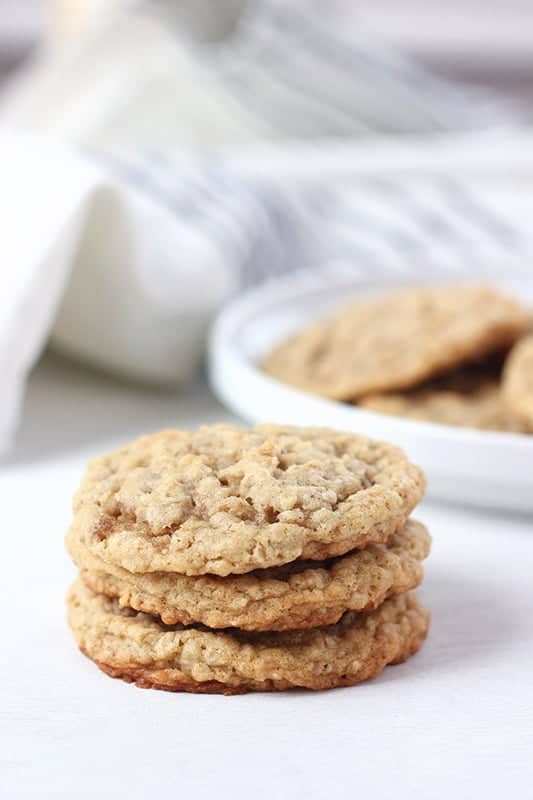 oatmeal cookies stacked in front of a plate with cookies