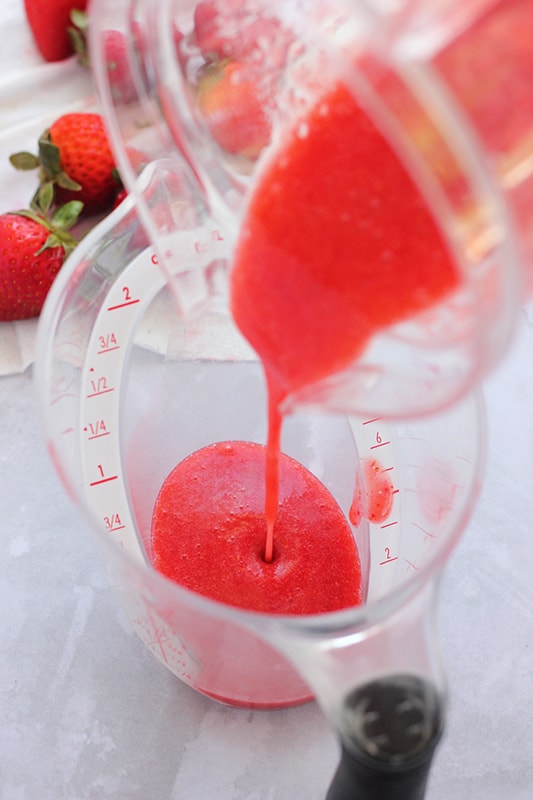 pureed strawberries poured into measuring cup