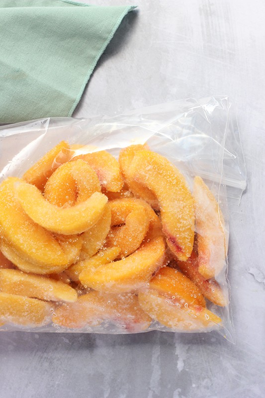 frozen peach slices in zip top bag on table top