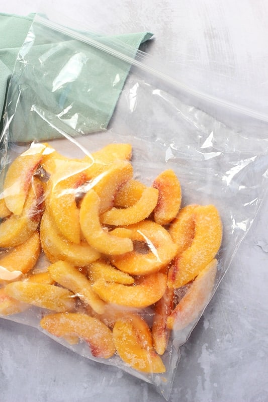 sliced peaches laid out in sip top bag, frozen