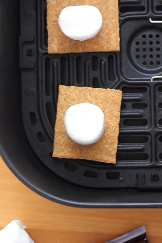 graham cracker squares placed in air fry basket and topped with marshmallows