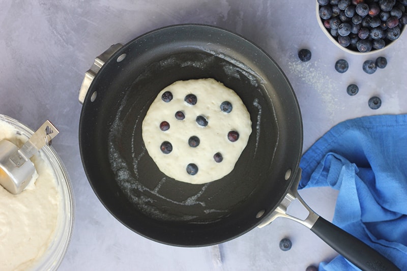 pancake sprinkled with blueberries in a pan