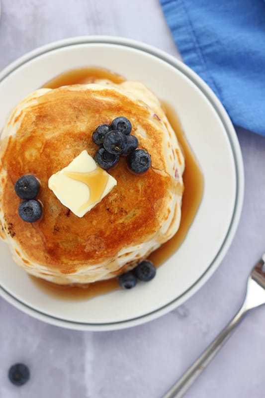 top down photo of a stack of blueberry pancakes with syrup
