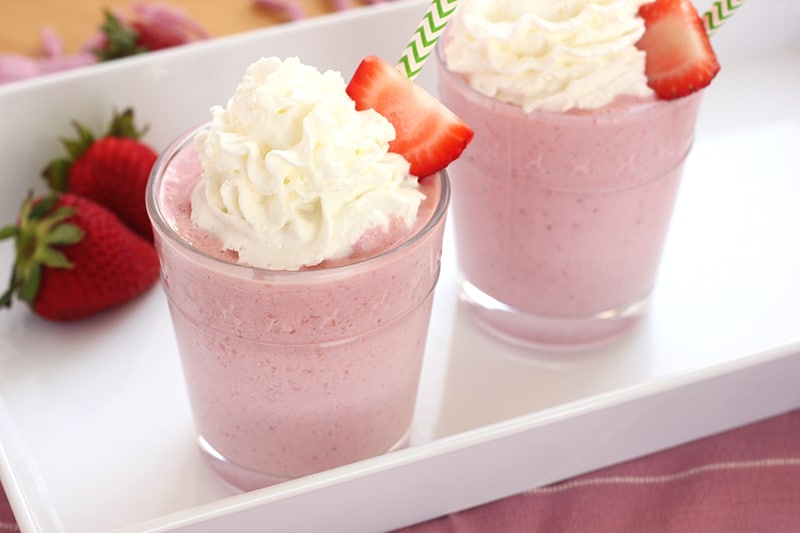 strawberry frappuccino in glass with whipped cream and fresh strawberry