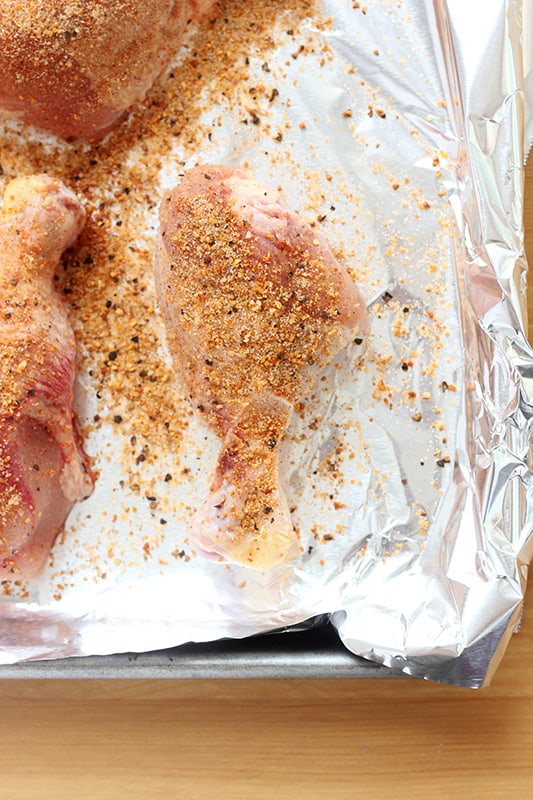 seasoned chicken drumstick on a foil lined tray