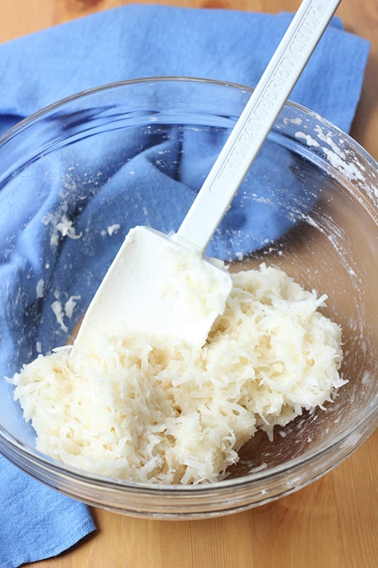macaroon batter being mixed in a glass bowl.