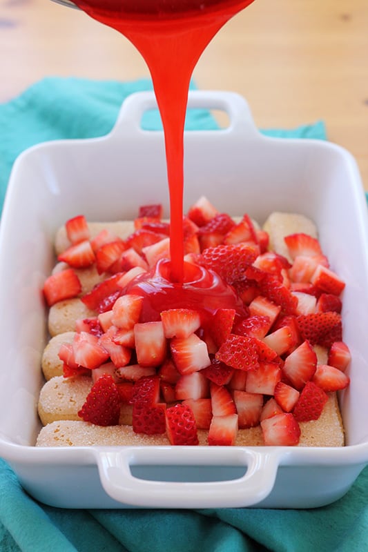 Danish Dessert pouring over the top of fresh strawberries and lady fingers