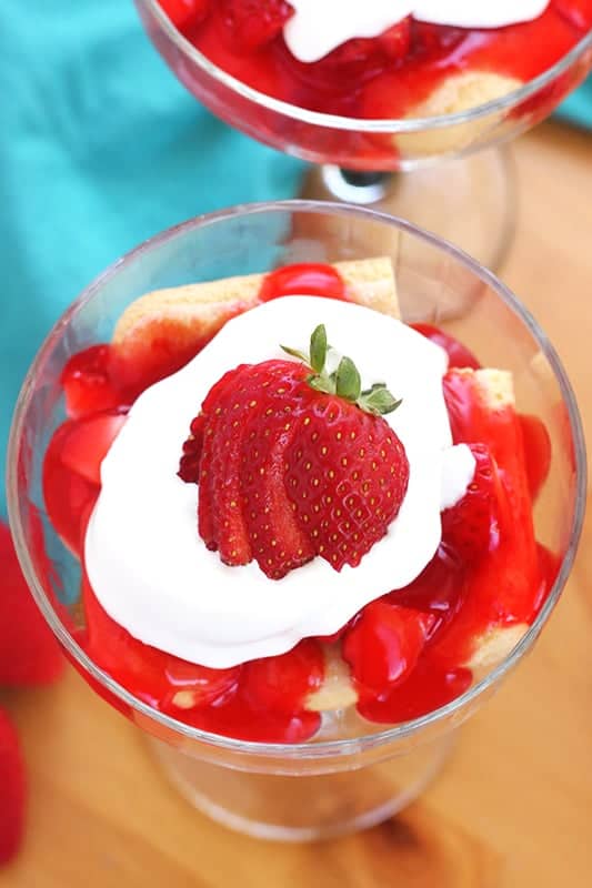 strawberry ladyfinger cake in a glass dish topped with fresh berries. 