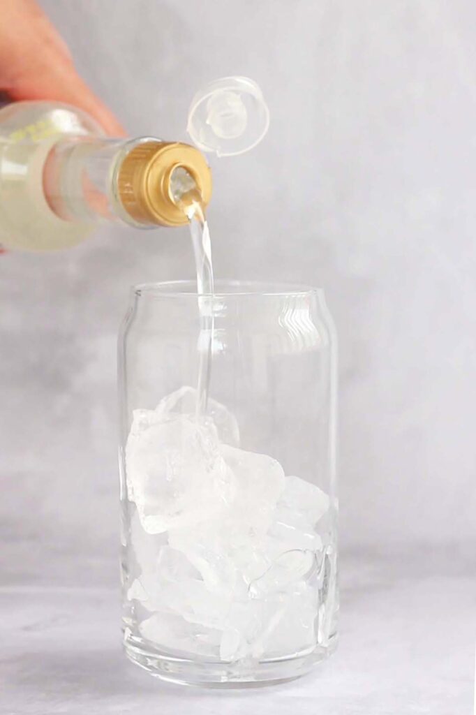 syrup being poured into a glass filled with ice