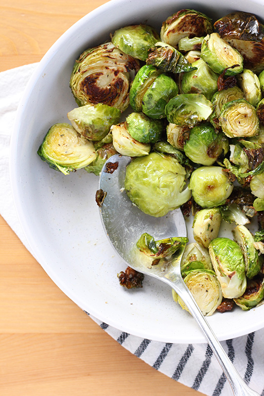 white bowl of brussel sprouts that have been roasted 