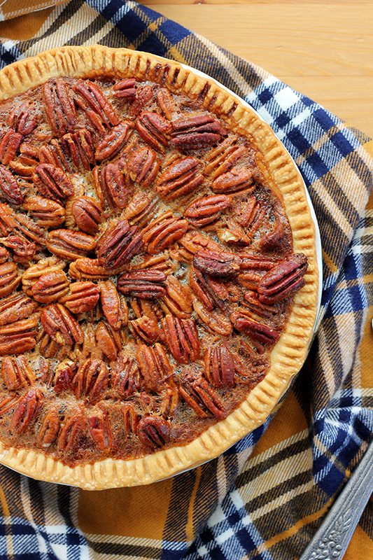 baked pie with pecans and chocolate on a table with a plaid napkin