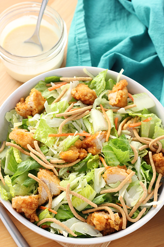 copycat applebee's salad in a bowl with dressing on the side in a jar